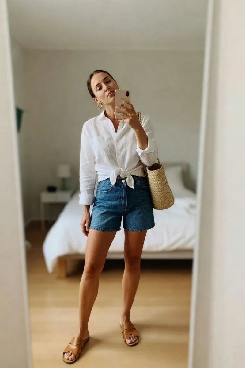 white button-down tied at the waist with denim shorts