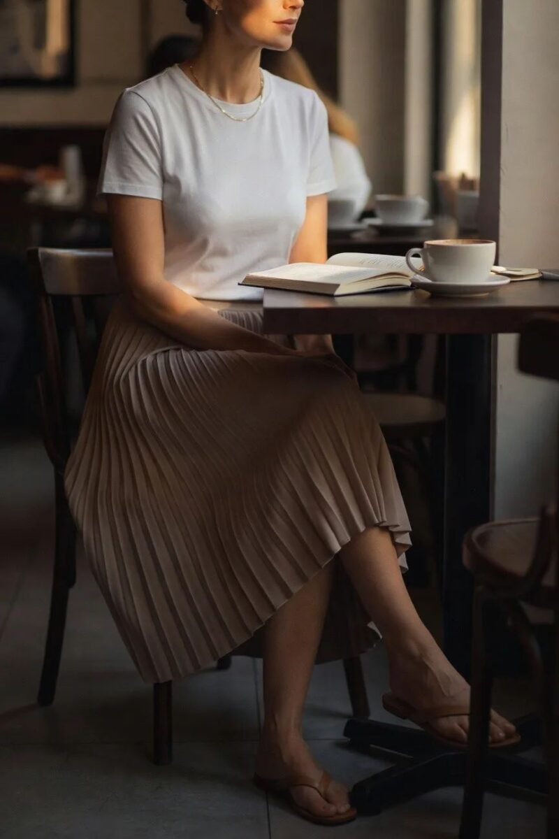 white tee tucked into a pleated midi skirt