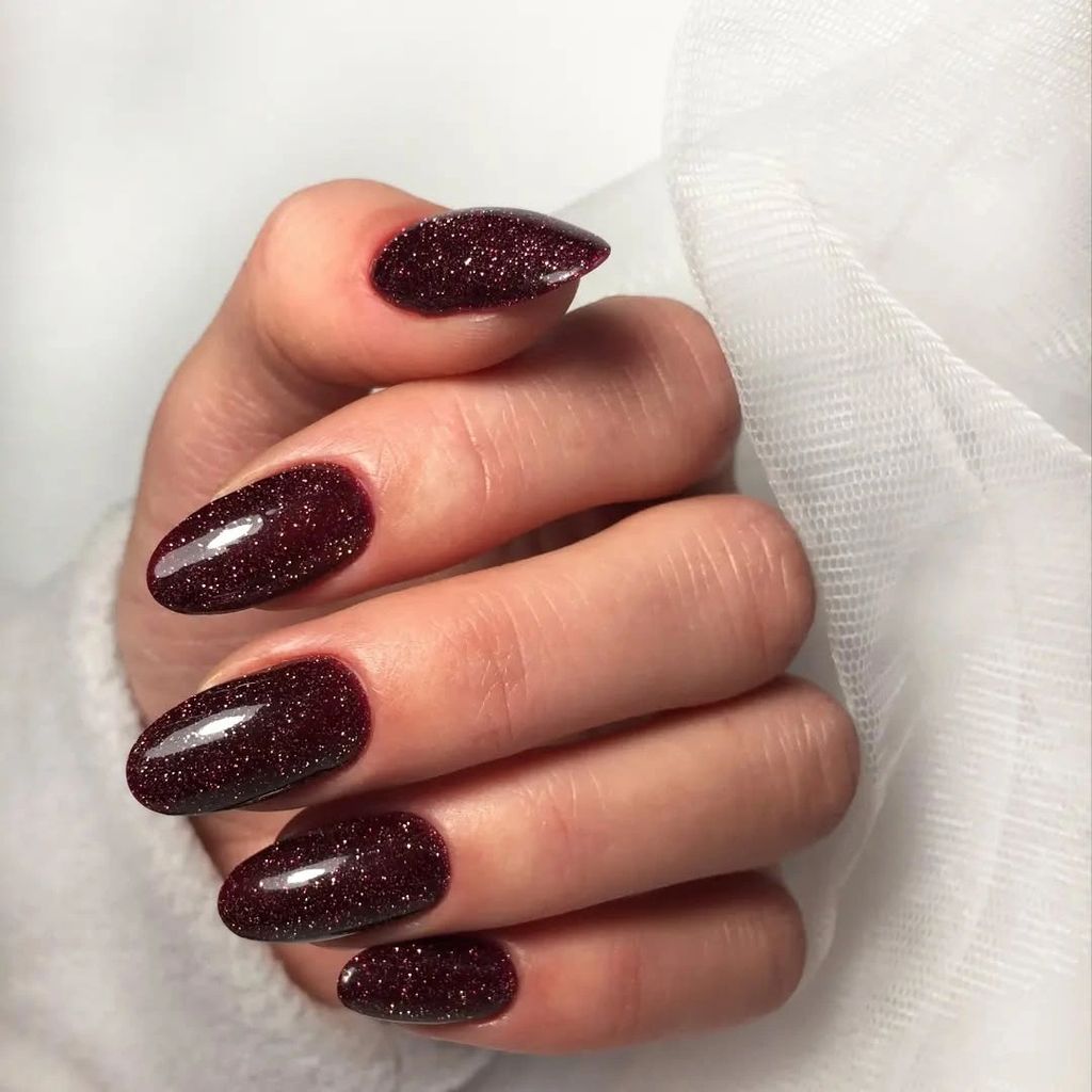 Long burgundy almond nails covered with fine red sparkle | Gorgeous Fall Burgundy Nail Designs: 21 Wine-Toned Ideas to Try