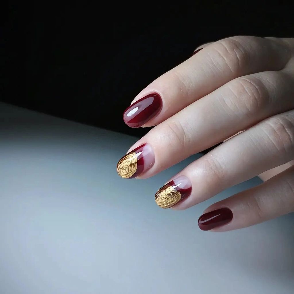 Short burgundy coffin nails with small gold tip accents | Gorgeous Fall Burgundy Nail Designs: 21 Wine-Toned Ideas to Try