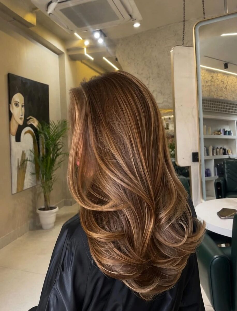 Long warm brown layered waves with caramel ribbon highlights
