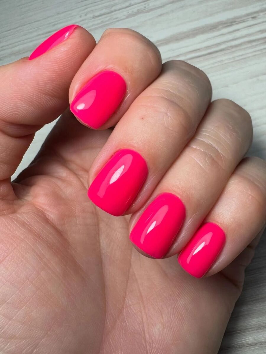 Short glossy hot pink square nails in a vivid solid color
