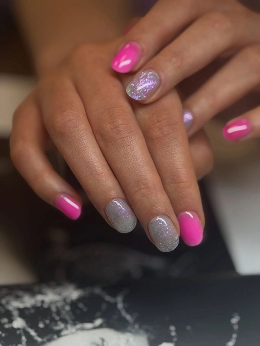 Short pink nails paired with soft silver glitter accent nails