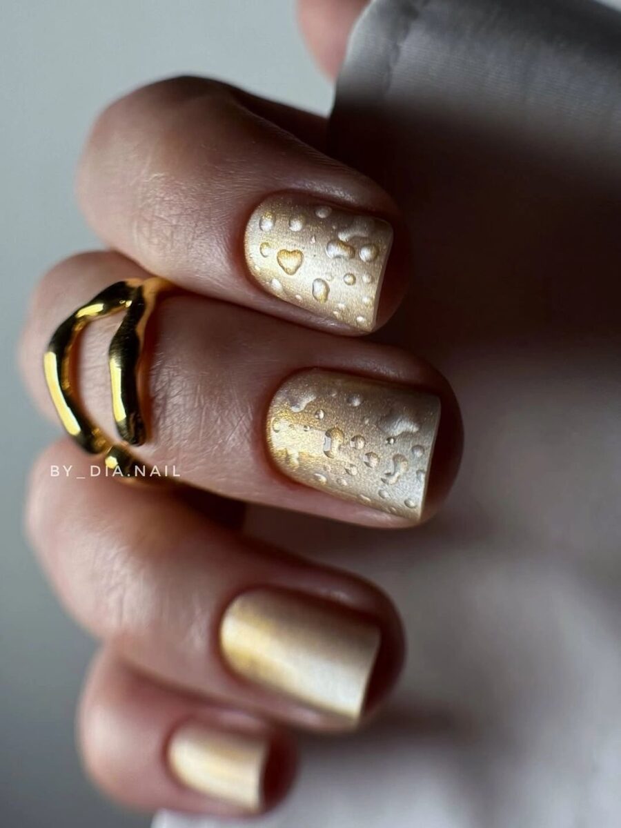 Short chocolate brown nails with thin gold bands and dots