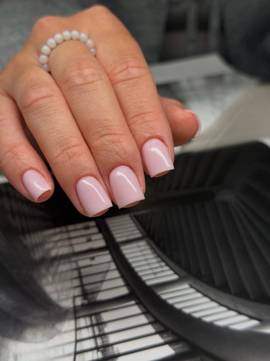Short glossy blush pink square nails with a clean simple finish