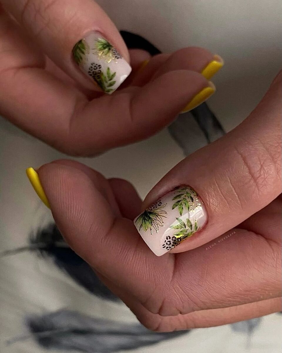 Short cream nails with yellow accents and tiny botanical details