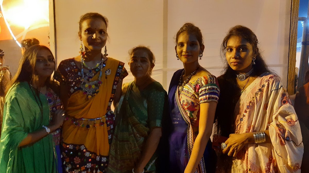 Group of women in traditional chaniya choli outfits with silver jewelry at a Navratri garba night