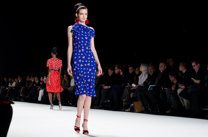 Model on the Carolina Herrera Fall/Winter 2014 runway wearing a cobalt-blue printed knee-length dress with a draped neckline.