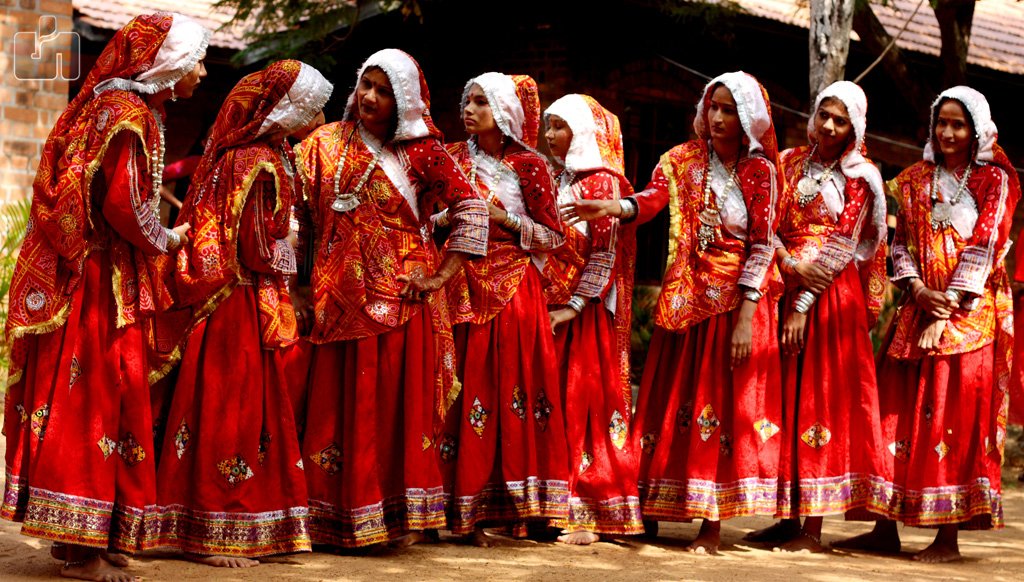 Women in red traditional Gujarati garba dresses with embroidered odhnis