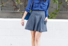 Woman wearing cobalt-blue velvet ankle boots with a royal-blue satin blouse and grey wool mini skirt.