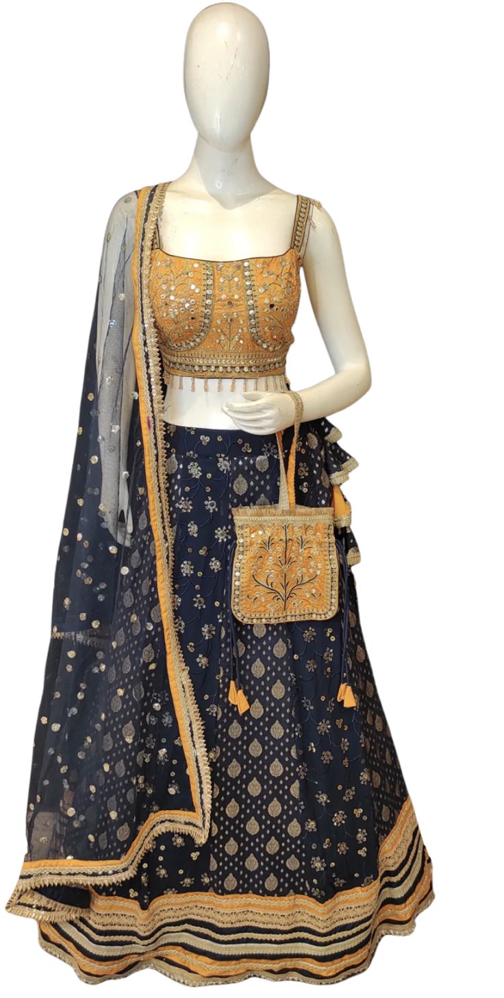 Navy blue lehenga with a mustard embroidered blouse and matching potli bag on a mannequin