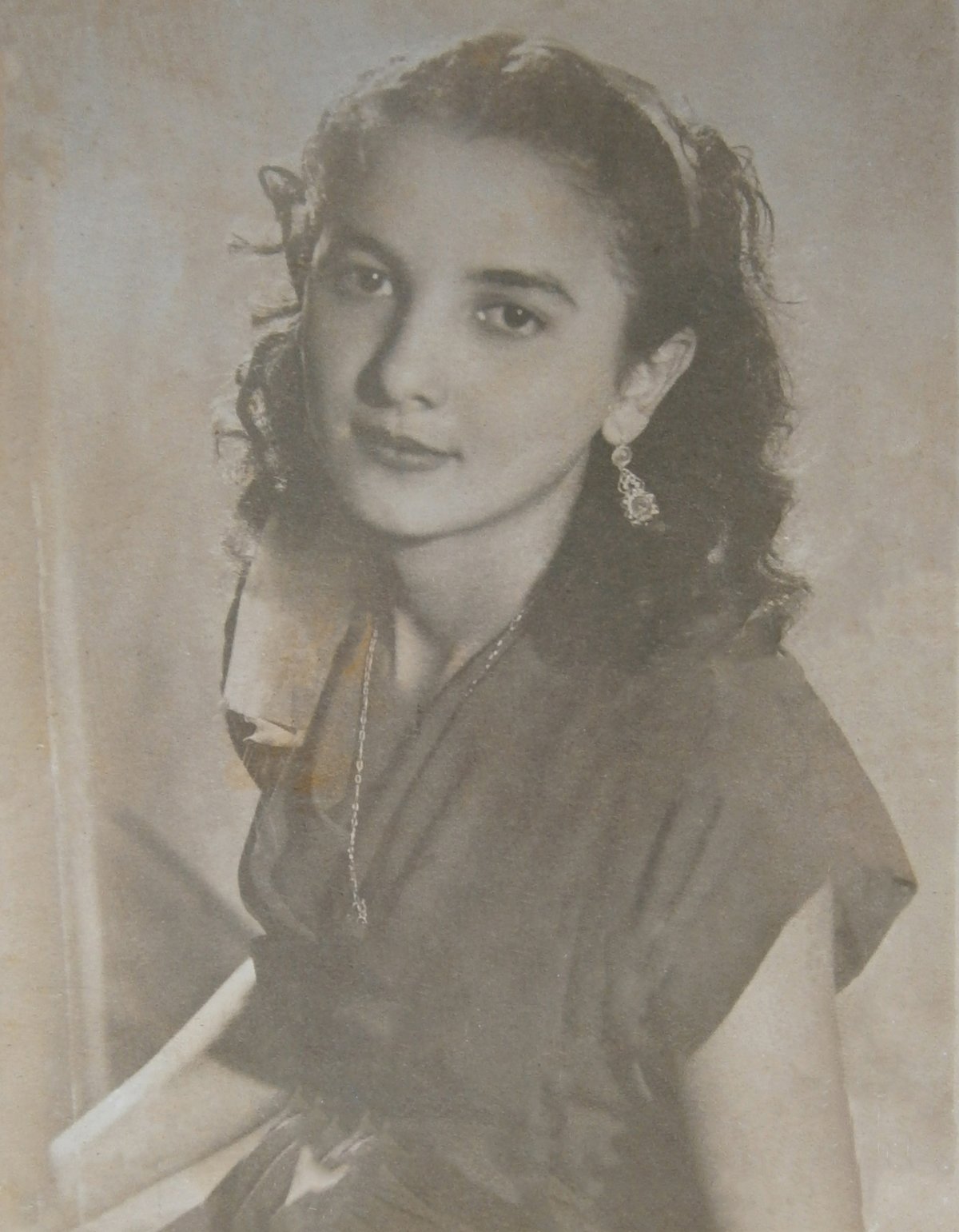 1948 studio portrait of a young woman wearing dangling earrings and a delicate necklace