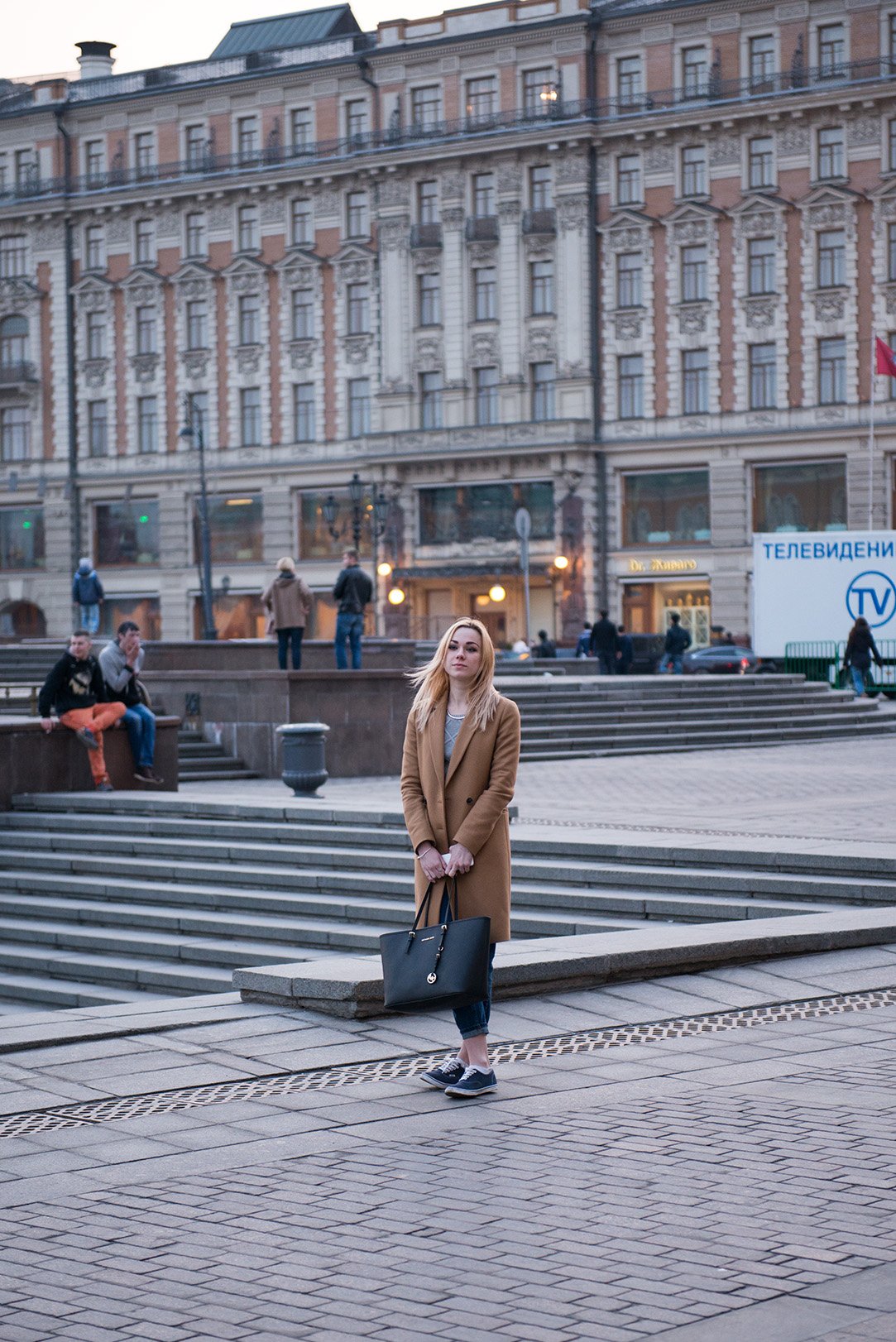 Camel wool coat with jeans and white sneakers