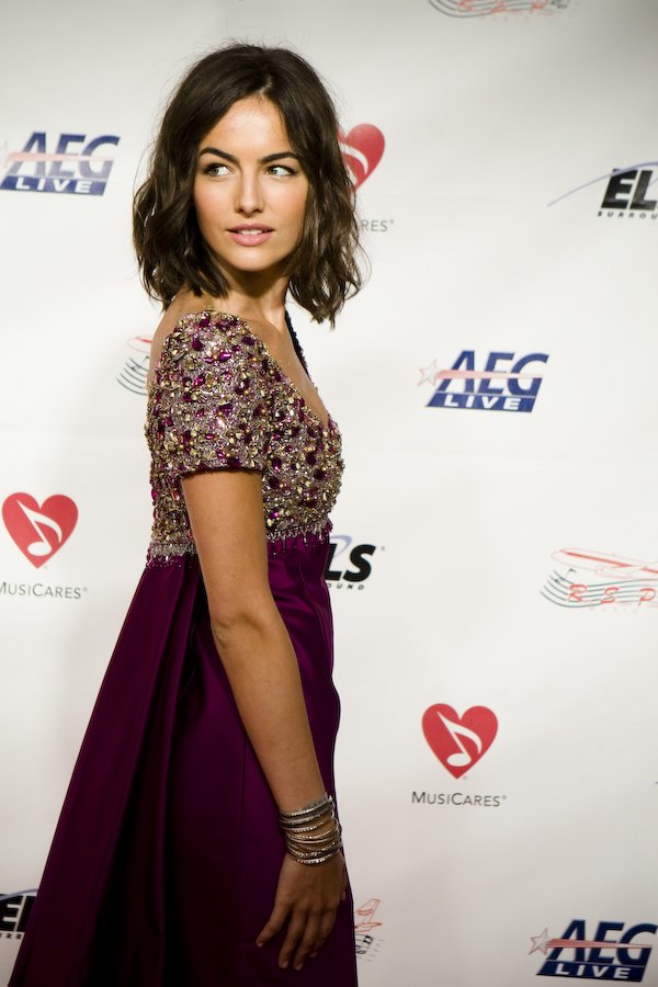 A woman wearing a gown with an embellished beaded bodice and a flowing dark skirt