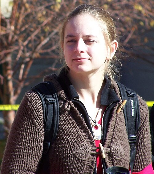 Close-up of a woman wearing a chunky brown knit cardigan with toggle buttons