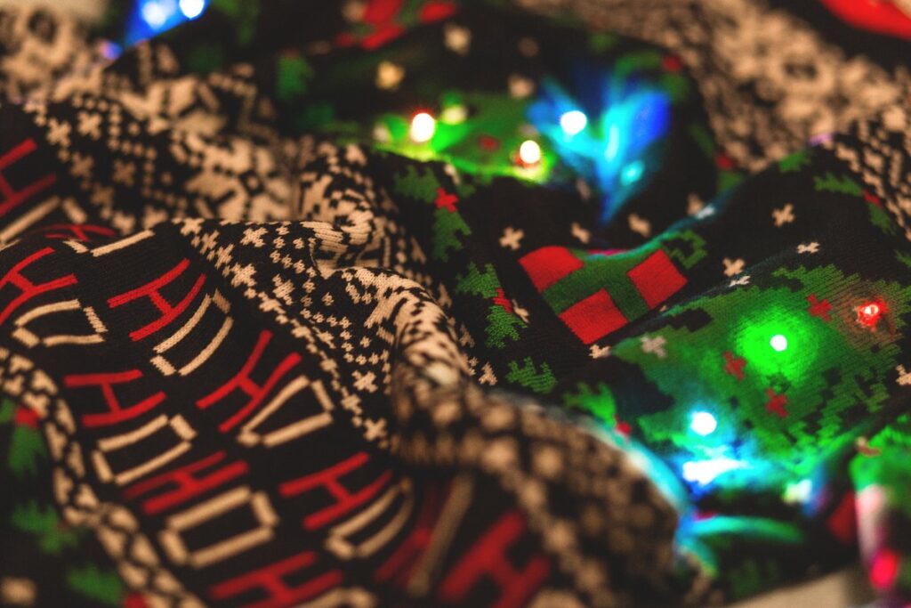 Close-up of a beige fair-isle Christmas sweater with LED lights glowing through the knit