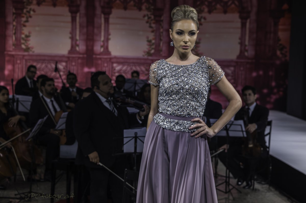 Model wearing a lilac tulle gown with a grey beaded bodice and short sleeves