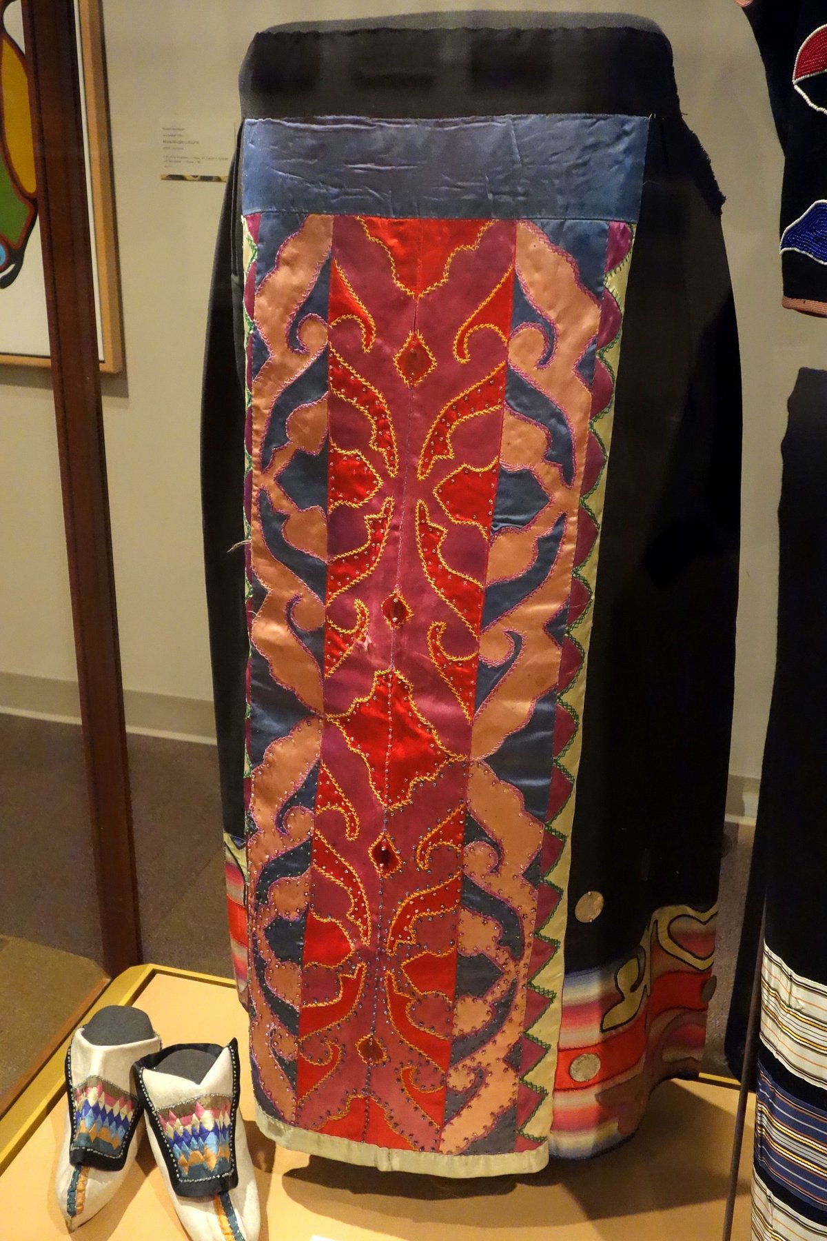 Early-1900s Mesquakie wool skirt with satin appliqué panels and beadwork on museum display