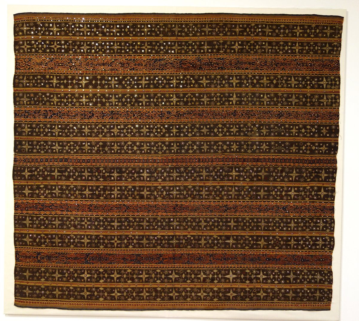 Early-20th-century Kauer ceremonial tapis skirt textile with glass mirror embroidery, displayed flat