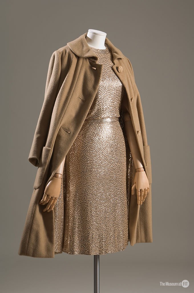 A gold sequin knee-length skirt with a camel coat on a mannequin, Norman Norell 1958 evening set
