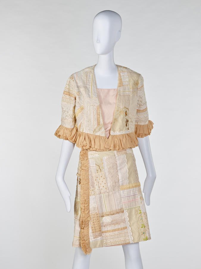 Patchwork-embroidered skirt suit with lace details on a mannequin