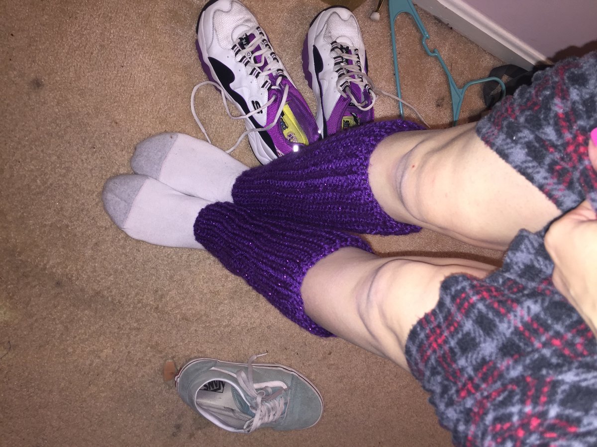 Purple knit leg warmers scrunched around the ankles
