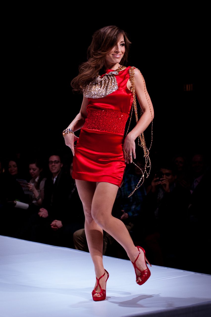 Natasha Gargiulo wearing a red satin mini dress with a sequined bib neckline on a runway